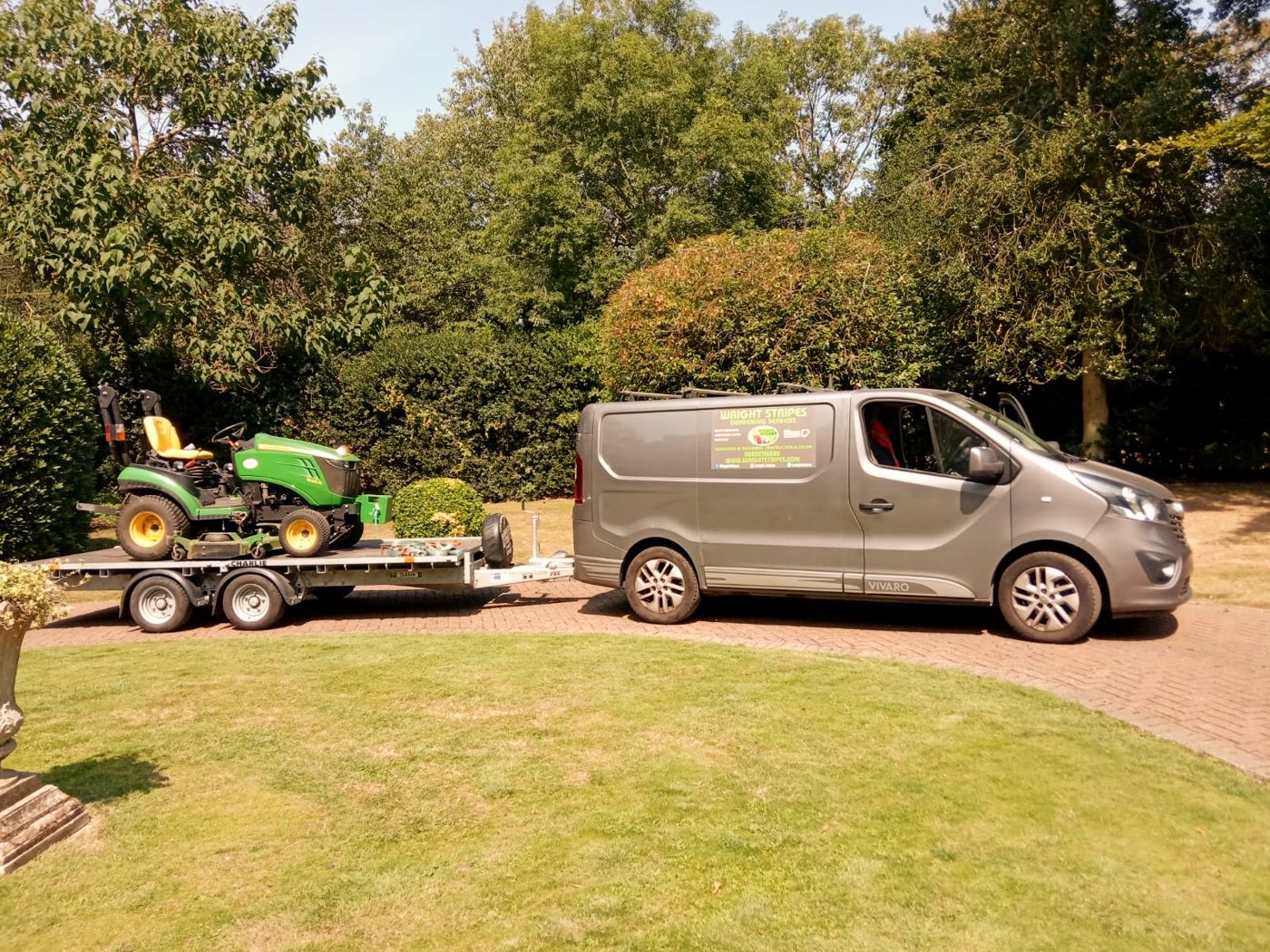 Wright Stripes branded van towing the ride-on mower beside a striped lawn